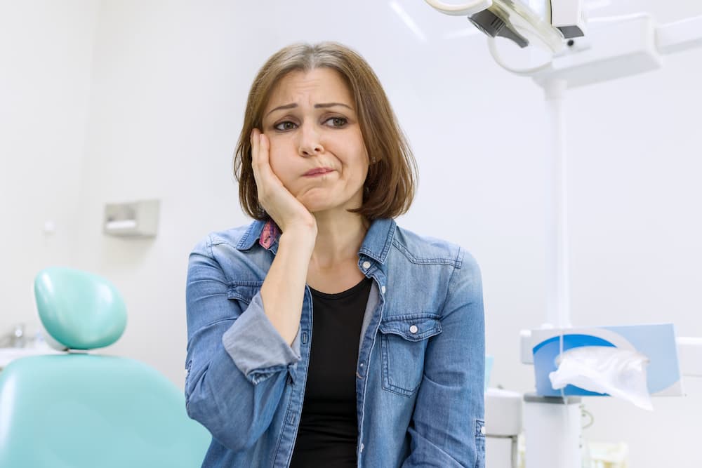 mature woman holding hands over head with toothach 2022 05 06 02 56 54 utc 1